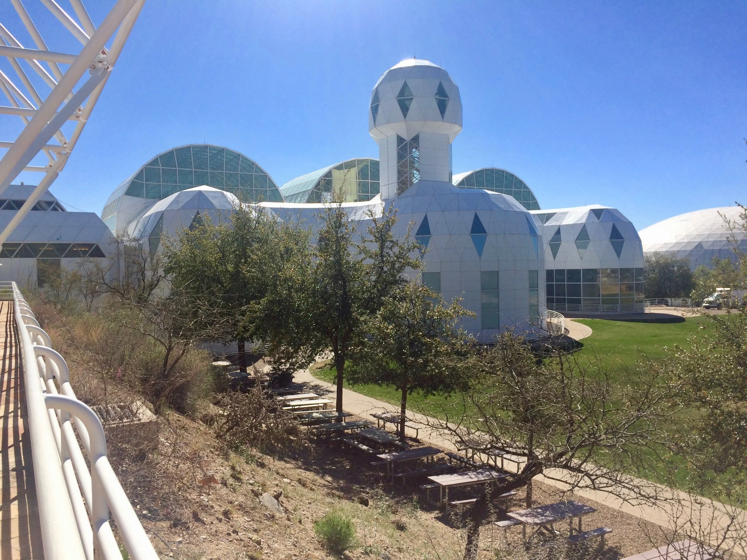 Biosphere 2’s white geometric human habitat, with a central tower and curved greenhouse roofs.